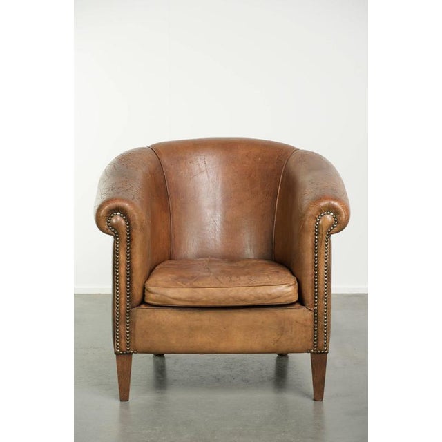 This rugged, well-worn vintage sheepskin club chair offers a comfortable seat and a beautiful color. The chair is crafted...