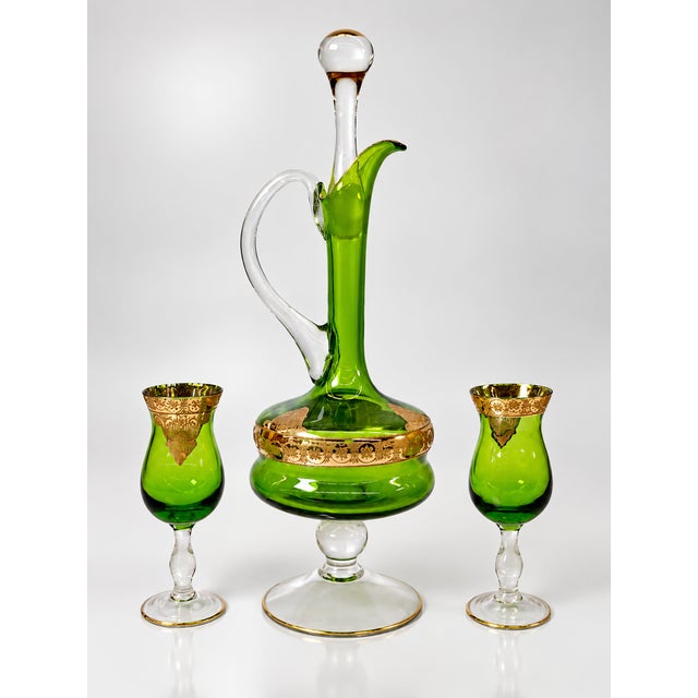 DESCRIPTION An exceptionally elegant seven-piece cordial service in brilliant emerald-green glass, distinguished by...
