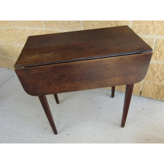 Dating from the 1700s is this incredible English drop leaf side table with one drawer. Made of oak, it is as solid as the...