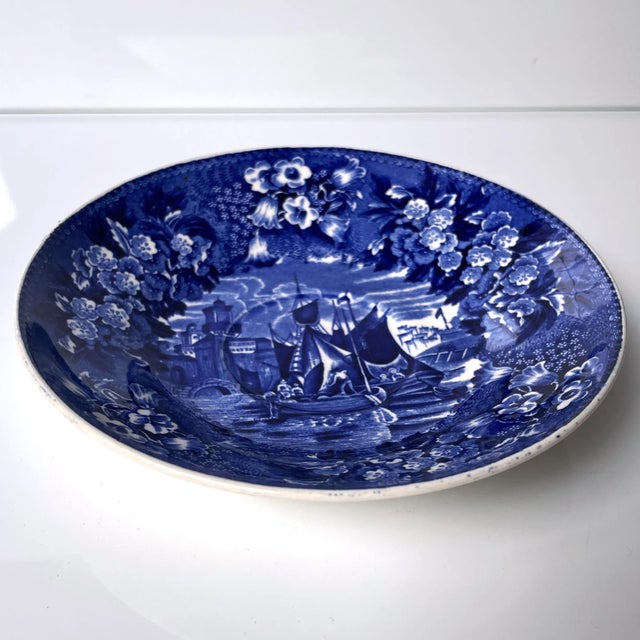 A beautiful Wedgwood blue & white transferware plate in the Ferrara pattern, depicting two sailing ships surrounded by a...