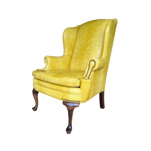 Make a sophisticated statement with this exceptional vintage Shuford Furniture yellow leatherette wingback armchair, a...