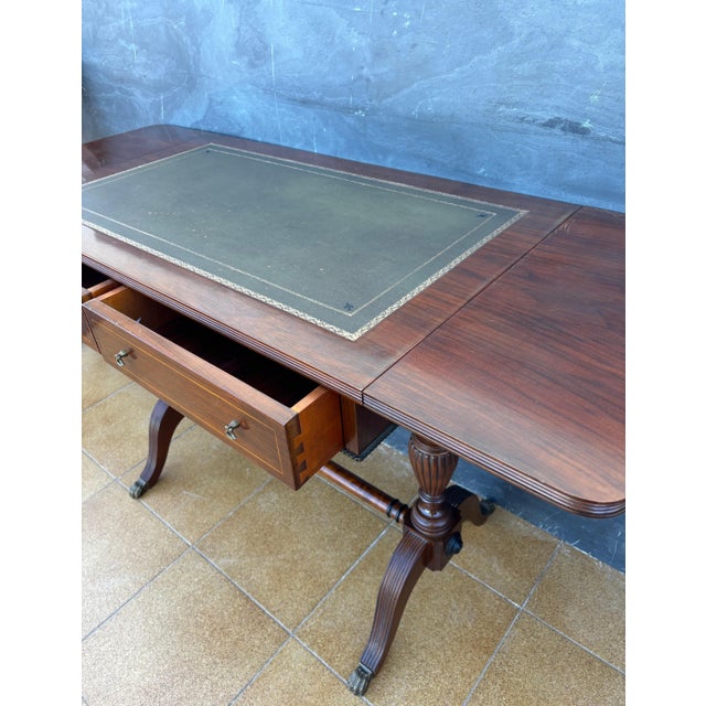 Spanish Regency Revival drop-leaf writing table crafted in solid wood, mid-20th century. Inspired by early 19th-century...