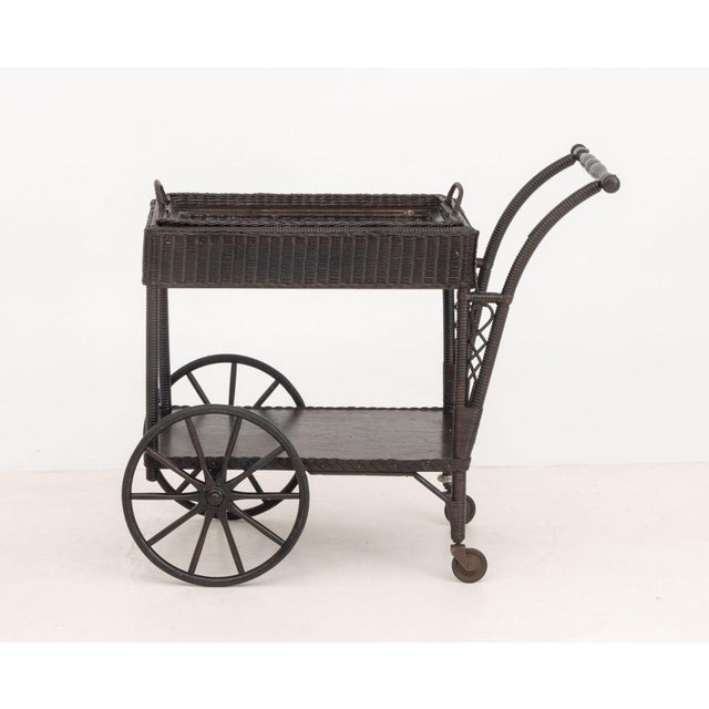 Vintage Brown Painted Wicker Tea Trolley, with removable serving tray above storage compartment on four wheels. 31" H x...