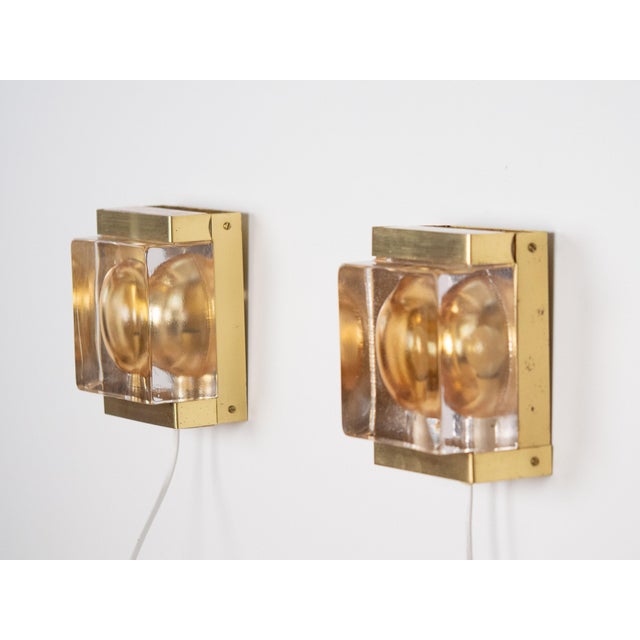 A pair of brutalist brass Maritim wall lamps. Their raw, sculptural form and geometric construction evoke the design of...