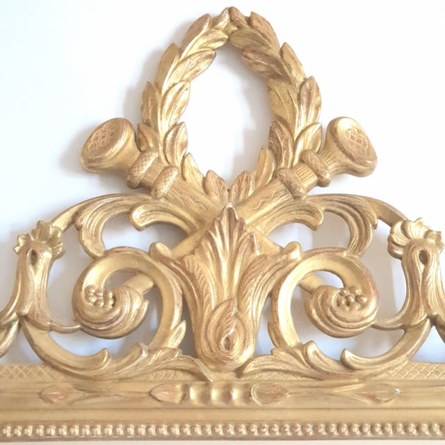 Louis XVI style giltwood mirror 20th century 1950 Gilt with gold leaf decorated with foliage, a laurel wreath, and...