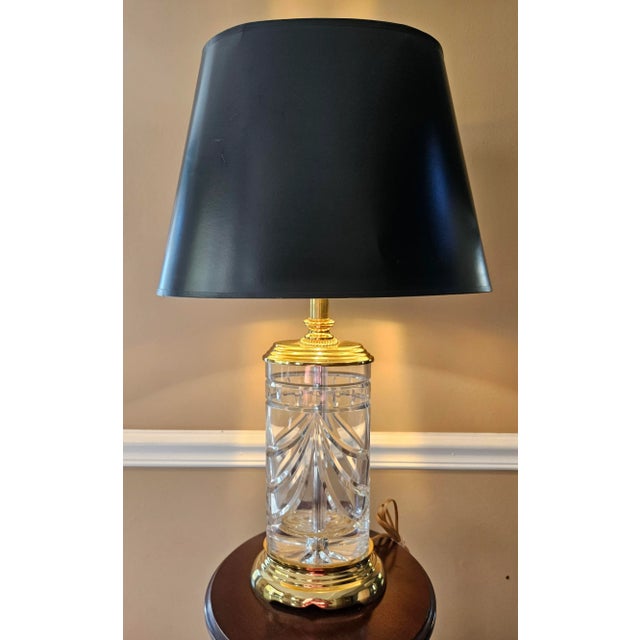 Waterford's "Overture" table lamp in cut crystal and brass. The ovoid crystal body is deeply cut with swags. The brass...