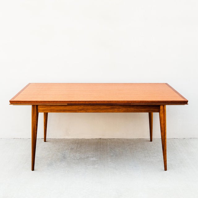 A rare and impressive modernist draw leaf dining table attributed to Gaston Poisson, made in France c. 1950s. The dining...
