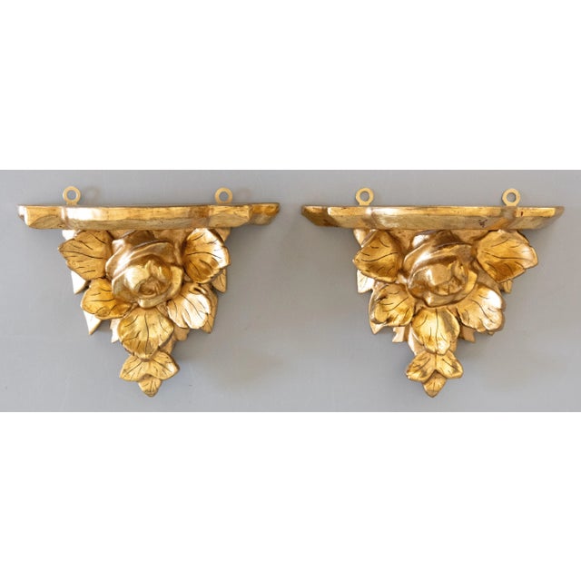 A lovely pair of vintage Italian gilded wood and gesso wall brackets shelves, circa 1940. They are decorated with lovely...