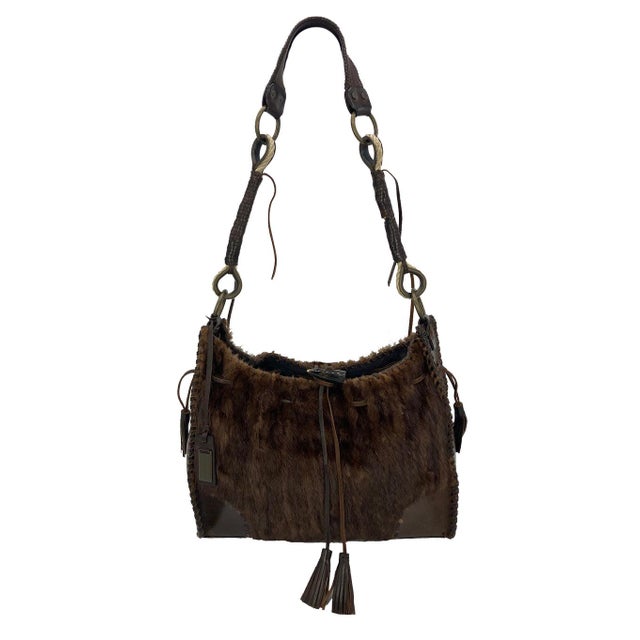 This exotic Dolce & Gabbana shoulder bag is in excellent condition. The exterior features gorgeous brown leather trimmed...