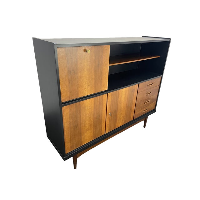 Mid-century modern walnut storage cabinet featuring a clean, architectural design with ample storage throughout. The piece...