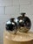 A striking pair of Art Deco Revival vases by Dolbi Cashier, crafted in cast metal with a highly polished gunmetal finish....
