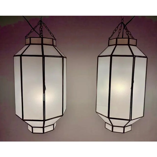This elegant pair of Art Deco-inspired chandeliers or pendants exudes timeless sophistication and architectural harmony....