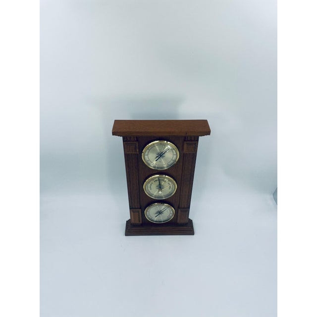 A vintage analog weather station manufactured in West Germany in the 1970s, housed in a wooden case. The station features...
