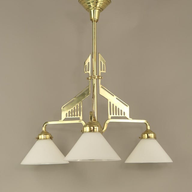 Massive brass chandelier with opal glass shade The lamp provides a cosy, non-dazzling light. Polished surface. European...