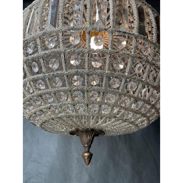 A beautifully detailed crystal spherical chandelier in a classic globe shape, full of sparkle and texture. The frame is...