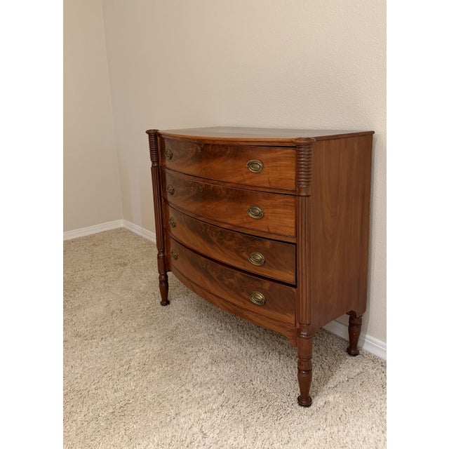 An American Federal period bowfront chest of drawers, circa 1810 to 1830, in richly figured flame mahogany. Four graduated...