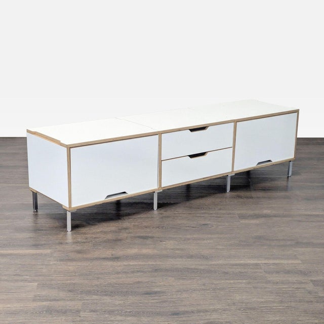 This Scandinavian Designs cabinet features a modern white finish with light wood accents and metal legs. It offers two...