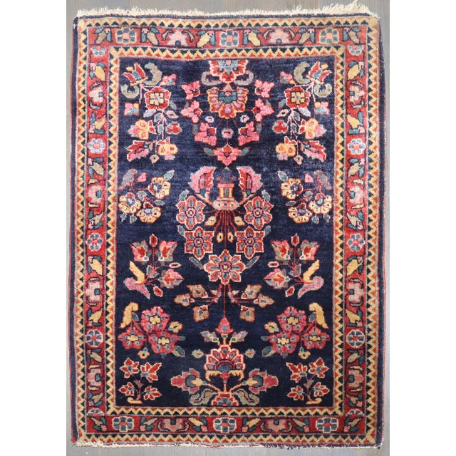 An authentic early 20th-century Sarouk carpet with a traditional formal design on a navy ground Measures: 1'10" x 2'6"...