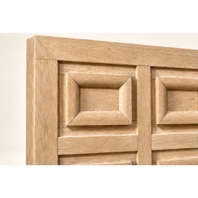 Large headboard in limed wood, featuring a characteristic sandy beige hue. The front panel is structured with ten...