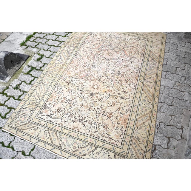 This is a vintage Turkish Oushak rug from the 1960s. The piece was hand-knotted.