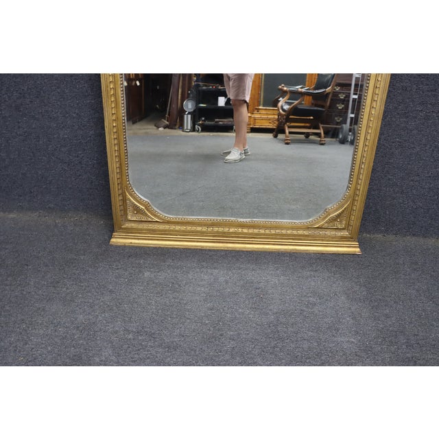 Late 19th century French Louis XVI style floor pier mirror with a carved giltwood frame and original beveled mirror plate....