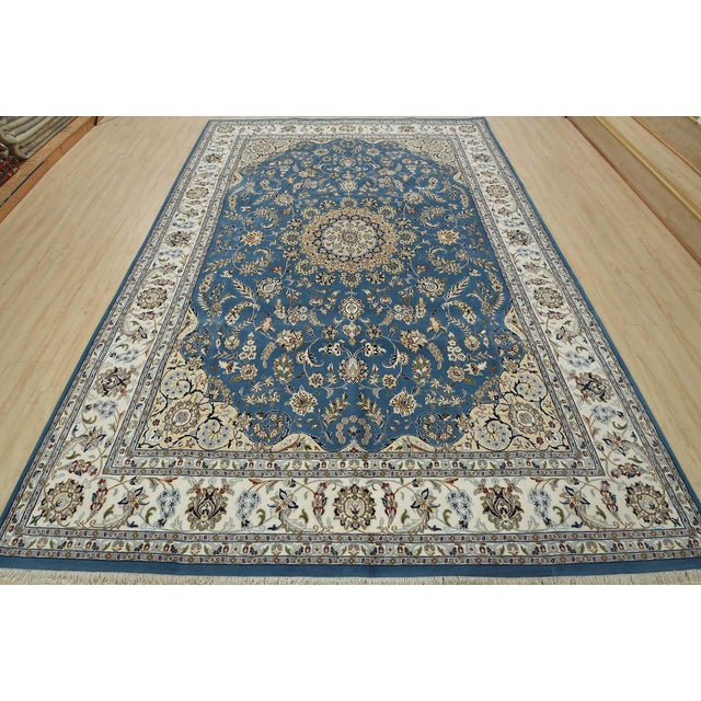 This traditional Nain rug is hand-knotted with an all-wool pile on a cotton foundation. This finely woven oriental rug...