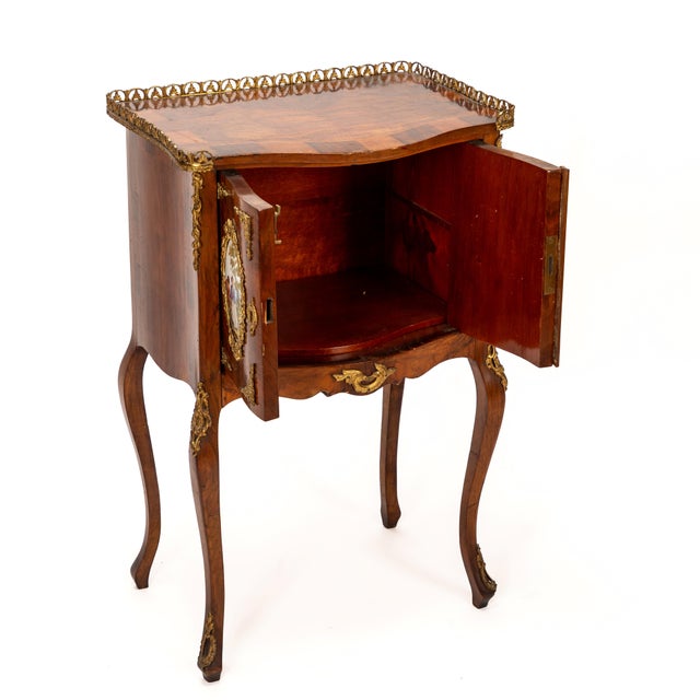 This stunning French Rococo commode features intricate ceramic plaques that add a unique artistic touch to its design. The...