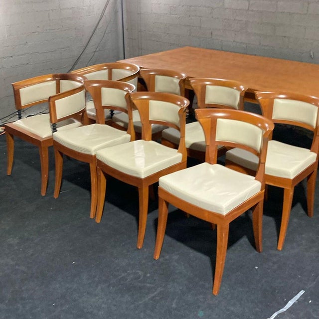 This Giorgetti dining set includes a large wooden table and 8 matching chairs. The table has a smooth wooden finish and...
