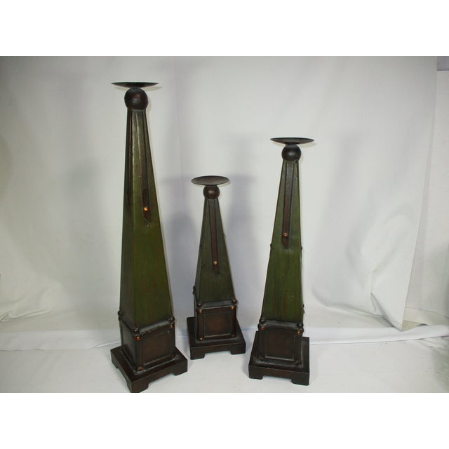 Set of 3 Arts and Crafts style pillar candleholders. Obelisk in shape, made of tin and painted with a deep green patina on...