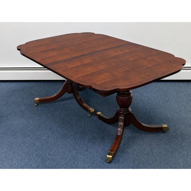 Beautiful vintage double-pedestal dining table featuring a rich mahogany-toned cherrywood finish and an elegant shaped top...