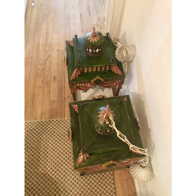 Pair of tole lanterns attributed to Chelsea House circa 1990. Four candle lights. Hardwired with canopies intact. Chain is...