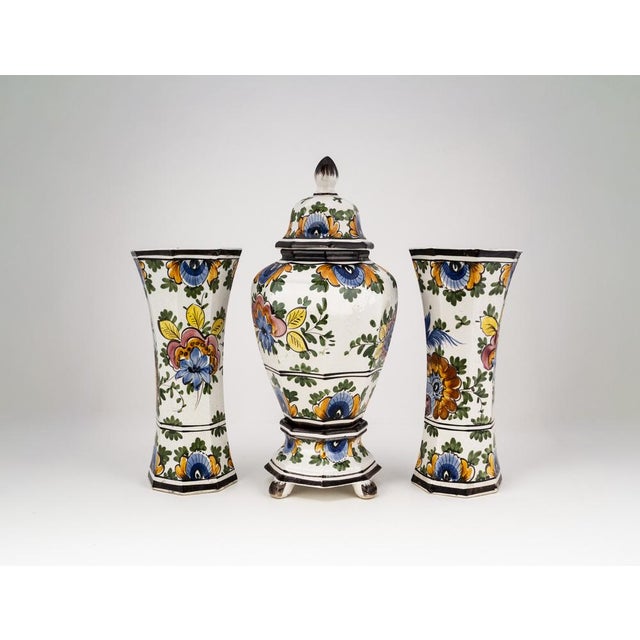 This three piece garniture set (Dutch: Kaststel) by the renowned manufacturer Oud Delftis a distinguished example of the...