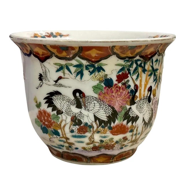 A vintage chinoiserie planter featuring a striking design of black and gold cranes. This exquisite cachepot boasts a...