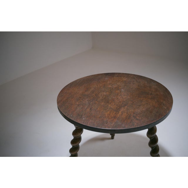French solid oak tripod side table dating from the 1930s. Crafted from solid oak, this small side table stands on three...