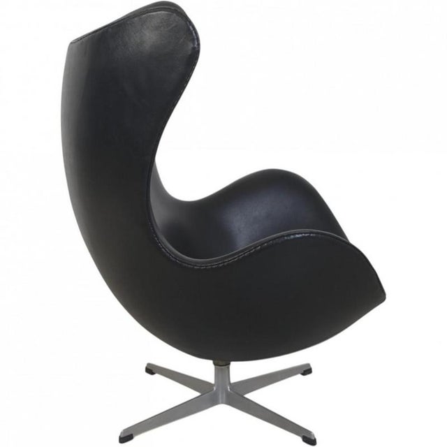 Arne Jacobsen vintage Egg chair upholstered in black leather, and with a base of fully casted aluminium. The chair is from...