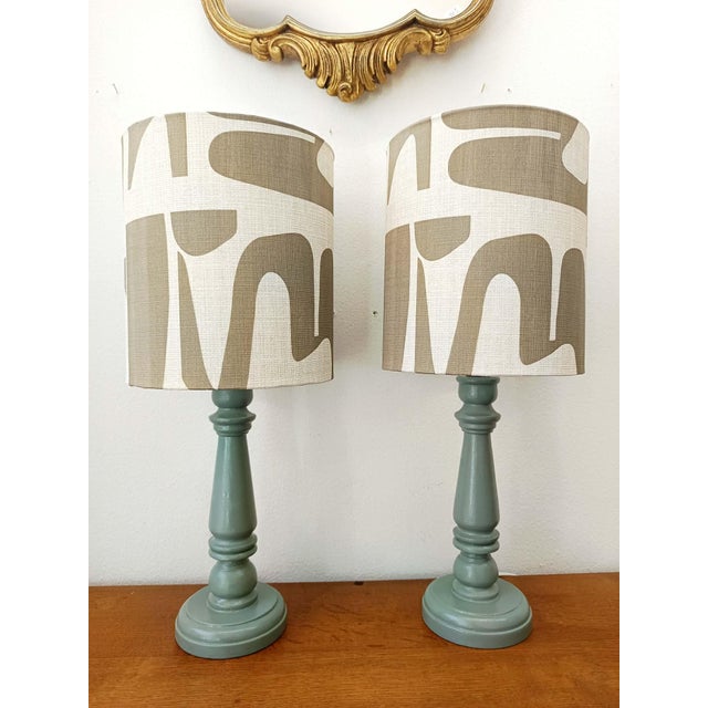 Pair of vintage lamps in sage green painted wood. Custom-made cylindrical lampshades upholstered in a modernist abstract...