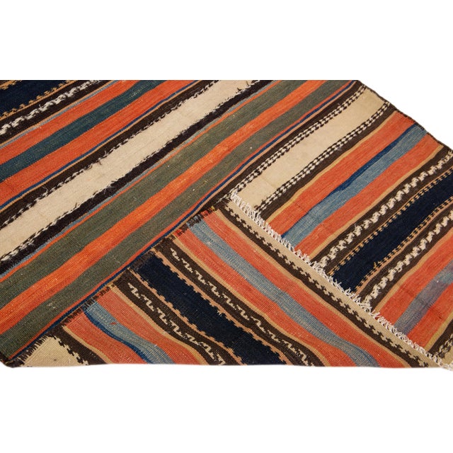 Beautiful vintage Turkish Kilim hand-knotted wool runner with an orange field. This rug has multicolor accents in an all-...