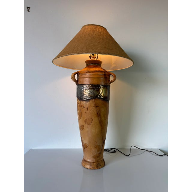 A striking 1980s vintage table lamp that exemplifies organic modern design, featuring a tall amphora-inspired base wrapped...