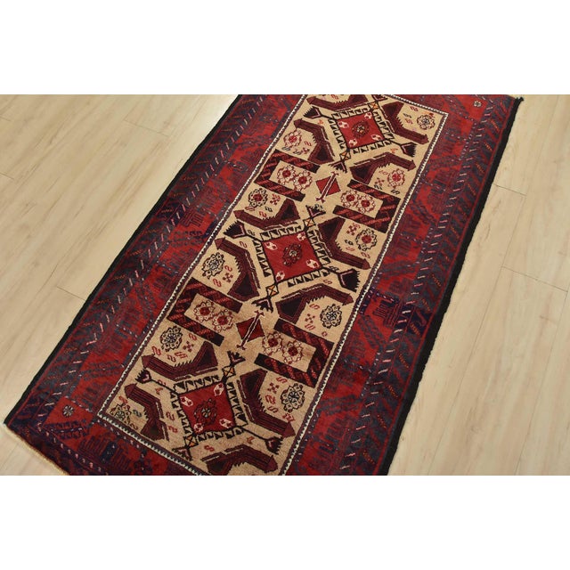 An authentic vintage tribal Baloch rug hand-knotted with fine wool and natural dyes. This nomadic oriental rug features a...