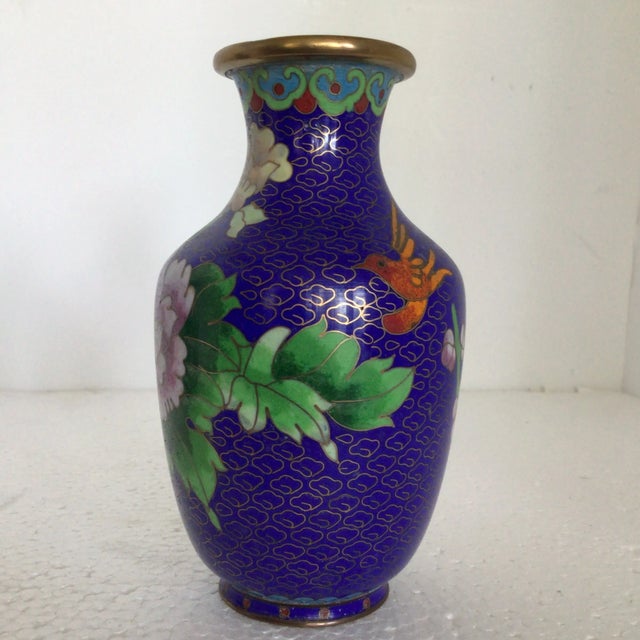 Here are a pair of deep blue cloisonné vases decorated with traditional Chinese wealth flowers. One of the vases has a...