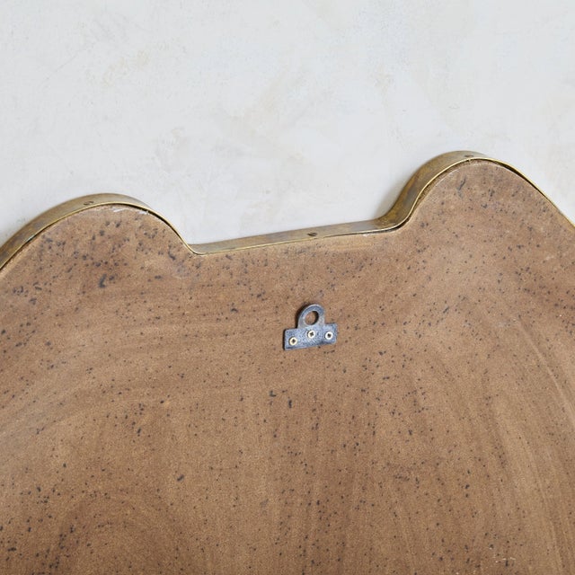 Sold and priced individually. A 1970s Italian shield shaped wall mirror featuring elegant curves along the top and a...