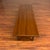 Vintage Danish modern teak coffee table with beveled edges and tapered legs with bowtie stretchers. It is a great size for...
