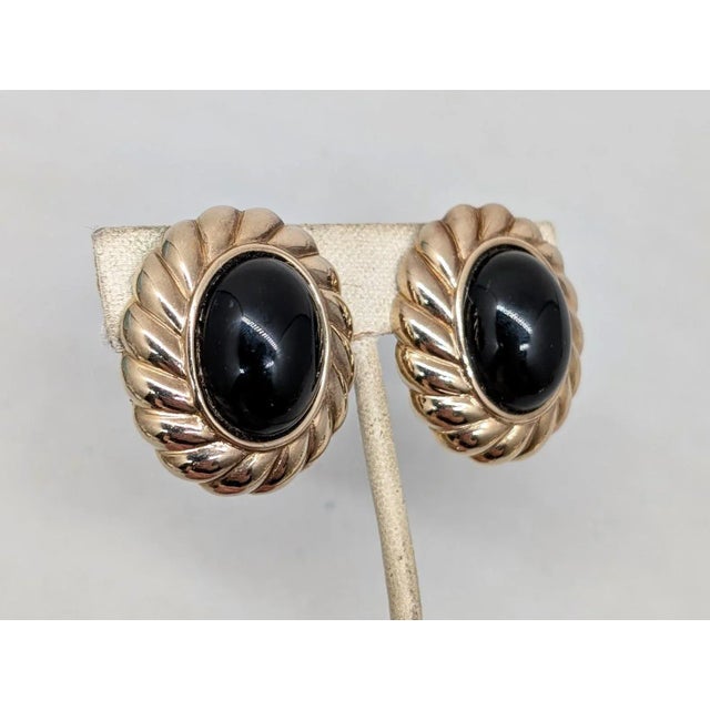 1980s oval goldtone with oval cabochon faux-onyx with ribbed edging clip earrings. Marked "PANETTA" on the clips and on...