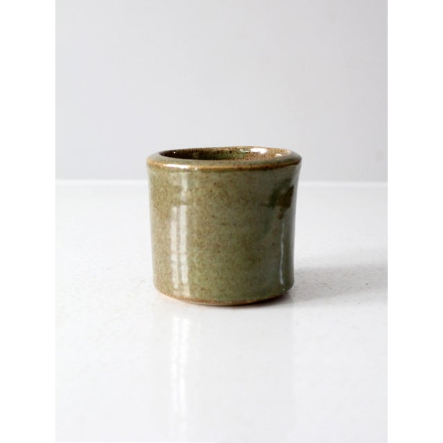 This vintage handmade studio pottery cachepot vase is signed by the artist and finished in a rich olive green speckled...