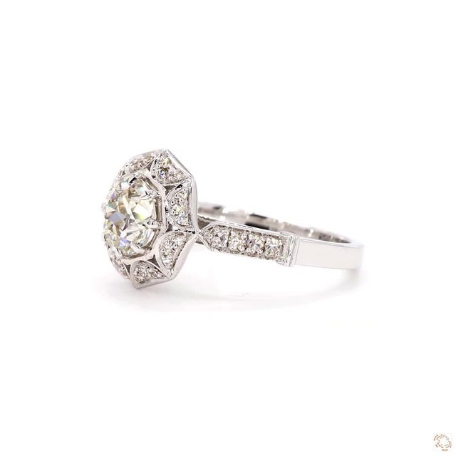 This estate ring, an early-twentieth-century antique design, centers on a 1.07-carat diamond in an old European cut, an...