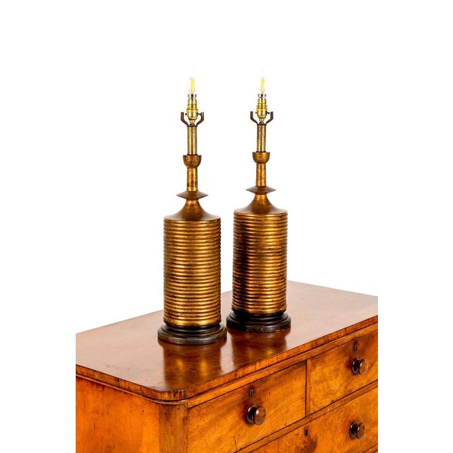 A wonderful pair of country house gilt table lamps procured from a Cornish estate. Turned wooden bases on circular gilt...