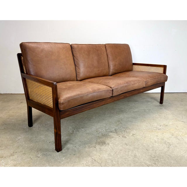 A rare 3-seat Danish modern sofa in rosewood and cane attributed to Bernt Petersen (unsigned). Original top grain leather...