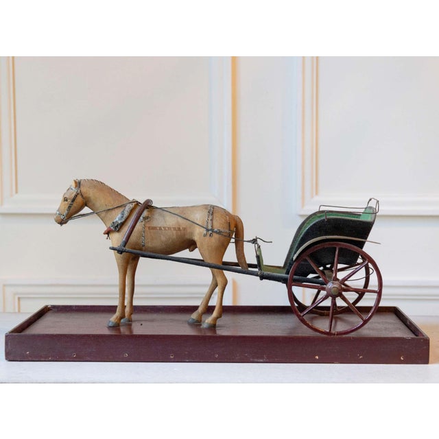 A charming horse and carriage model dating from the first part of the 20th century, composed of a carved wooden horse and...