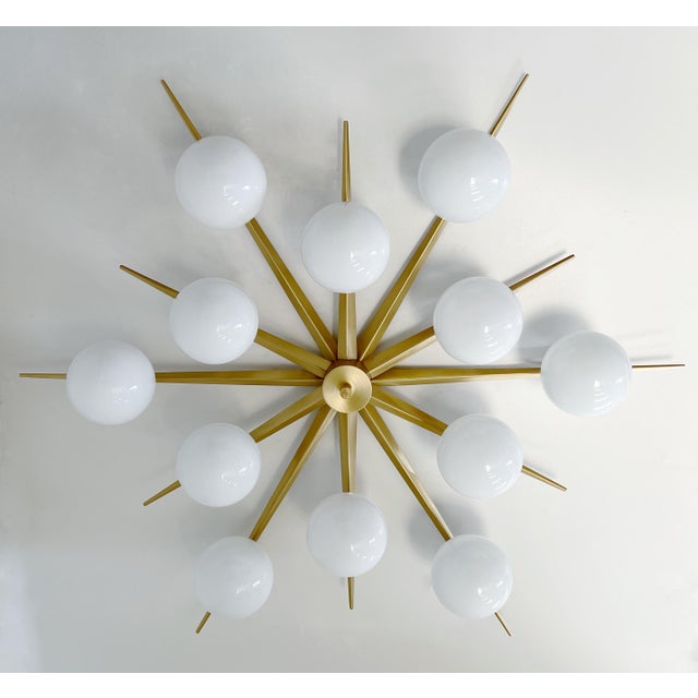 Italian midcentury flush mount with 12 large glossy white Murano glass globes mounted on solid brass frame in satin brass...