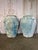 An impressive pair of oversized terracotta urns showcasing a richly weathered surface with traces of blue mineral patina....